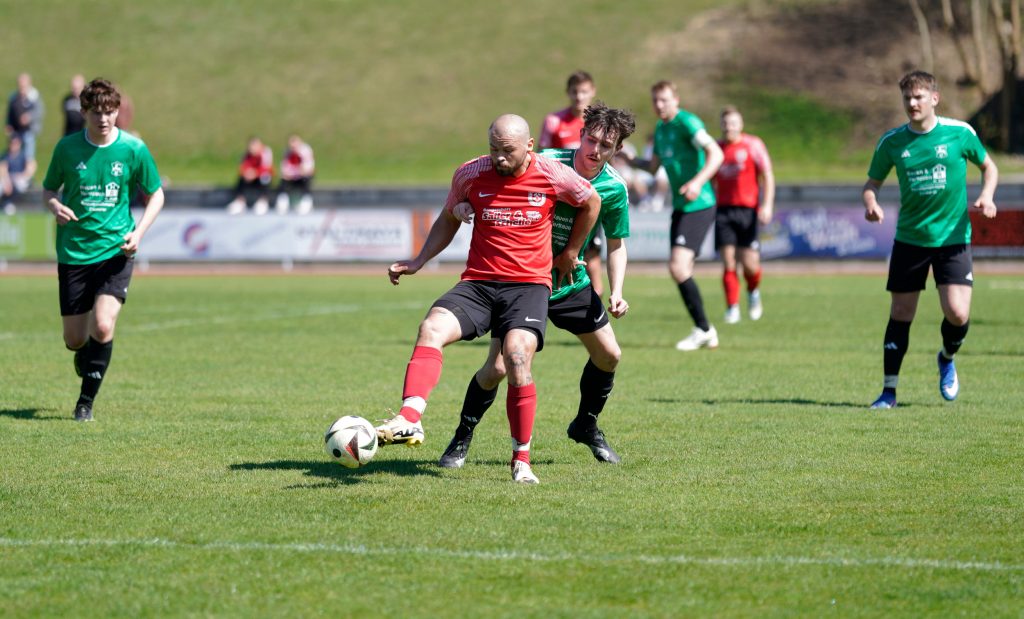 Foto zeigt einen Peißenberger Spieler mit dem rechten Fuß den Ball spielend und gleich hinter ihm der Gegner.