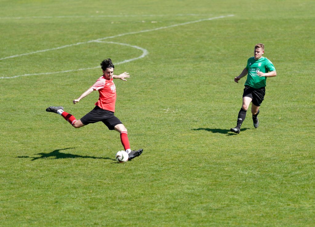 Foto zeigt einen Peißenberger Spieler mit dem rechten Fuß ausholden um den Ball zu spielen..