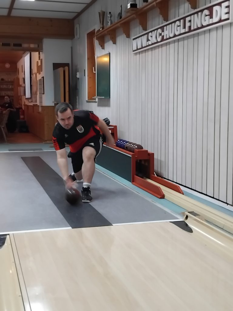 Foto zeigt einen Peißenberger Kegler beim Warmmachen und von Vorne wo die Kugel gerade seine Hand verlässt und auf die Bahn trifft.