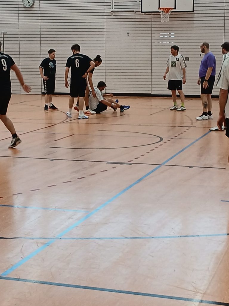 Bild zeigt in der Glückauf Turnhalle das Handball Spiel der Herren des TSV Peißenberg gegen den SV Ettal mit einer Aktion vor dem Kreis der Ettaler und einem gefaulten Spieler.