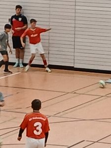 Bild zeigt drei spielende Fußball Spieler in der Halle.