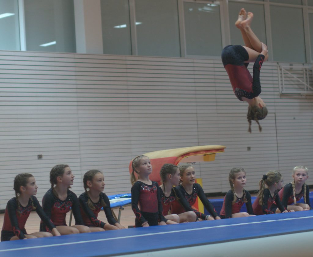 12 Foto vom Weihnachtsturnen in der Glückauf Turnhalle zeigt eine Teilnehmerin im Überschlag auf der Matte.