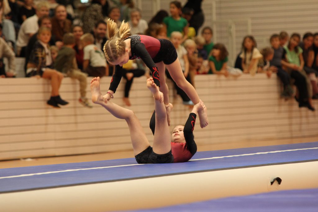 6 Foto vom Weihnachtsturnen in der Glückauf Turnhalle zeigt zwei Teilnehmerinnen auf der Matte im Überschlag.